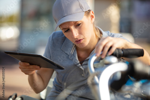 young woman servicing public rental bikes