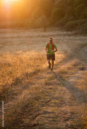 trail runner running at sunset