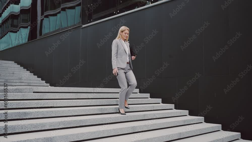 Busienss lady with gadgets in hands going down street stairs Busienss lady with gadgets in hands going down street stairs