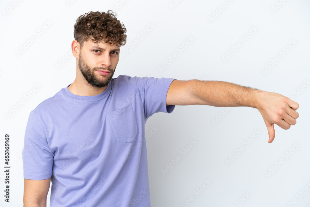Young handsome caucasian man isolated on white background showing thumb down with negative expression Young handsome caucasian man isolated on white background showing thumb down with negative expression