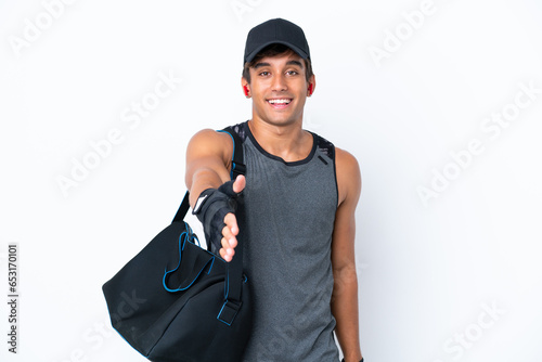 Young sport caucasian man with sport bag isolated on white background shaking hands for closing a good deal