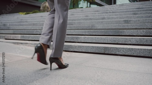Businesswoman in high heels walking stairs outdoors