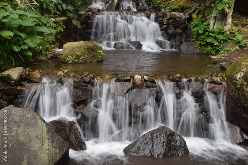 waterfall in a small river full of steep rocks in the middle of the forest