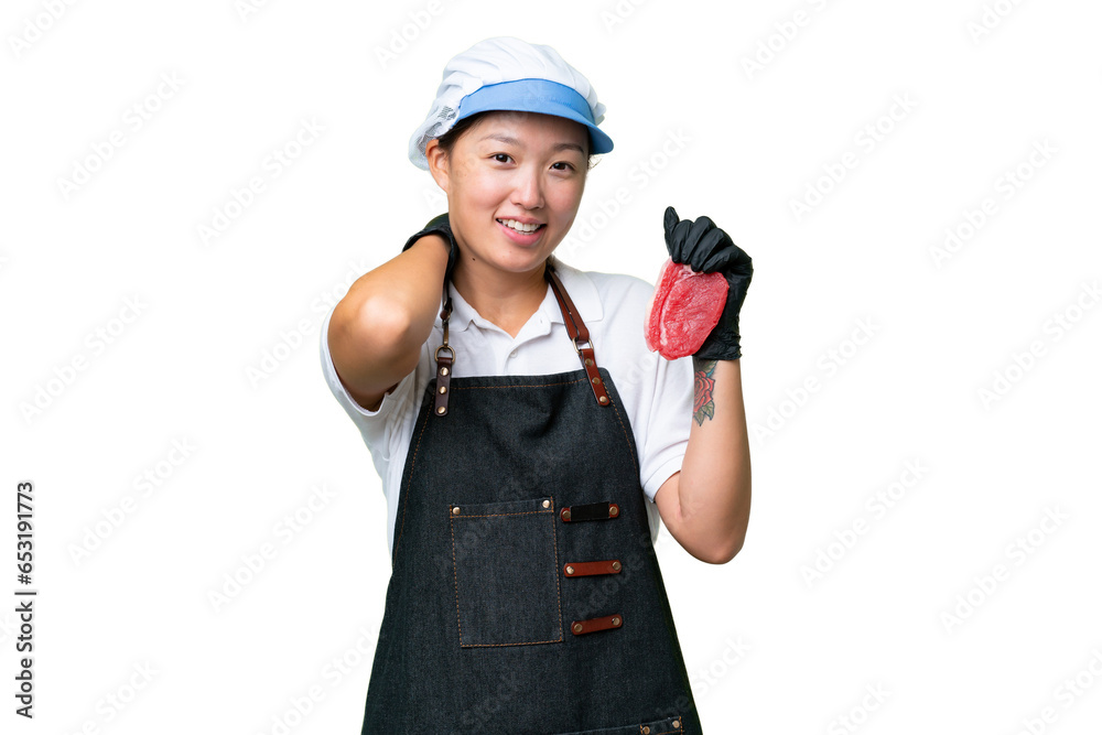 Young caucasian woman wearing an apron and serving fresh cut meat over isolated background laughing Young caucasian woman wearing an apron and serving fresh cut meat over isolated background laughing