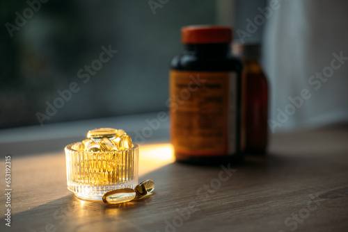 Benefits of Omega-3 for Cold Winter Months. Omega-3 fish oil Yellow Soft capsules in glass bottle on table at home. Take care of your health with fish oil