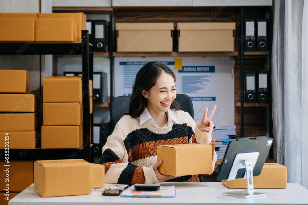 Asian woman SME working with a box the workplace. start up small business owner, small business entrepreneur SME and delivery concept. Asian woman SME working with a box the workplace. start up small business owner, small business entrepreneur SME and delivery concept.