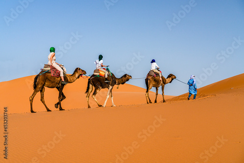 Family with one child enjoying a camel ride in the desert, Erg Chebbi, Merzouga, Sahara Desert, Morocco photo