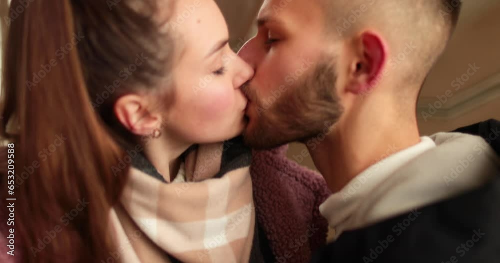 A young couple in love say goodbye with passionate kisses and hugs after a romantic date in the hallway of an apartment building. A young couple in love say goodbye with passionate kisses and hugs after a romantic date in the hallway of an apartment building.