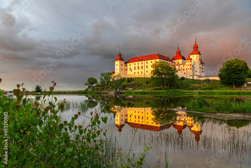 Lacko Castle and the reflection in the water at sunset, Kallandso island, Vanern lake, Vastra Gotaland, Sweden, Scandinavia photo