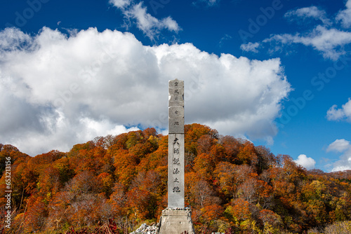 Stone pillar with kanji against a beautiful autumnal landscape, Osorezan Bodaiji Temple, Mutsu, Aomori prefecture, Honshu, Japan