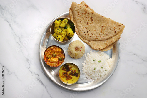 Indian vegetarian Thali or platter includes Aloo ki sabji, dal rice, Roti bhaji, Matar Paneer, Sheera or suji ka halwa, chapati. Indian food is served in a Silverplate or thali. Copy Space. Veg Thali photo