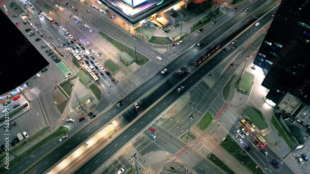 Aerial drone night video of illuminated Crossroad, multi lane highway through urban city center popular multilevel junction