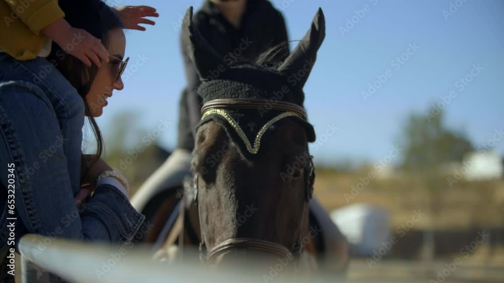Mother and daughter petting horse - close up Mother and daughter petting horse - close up
