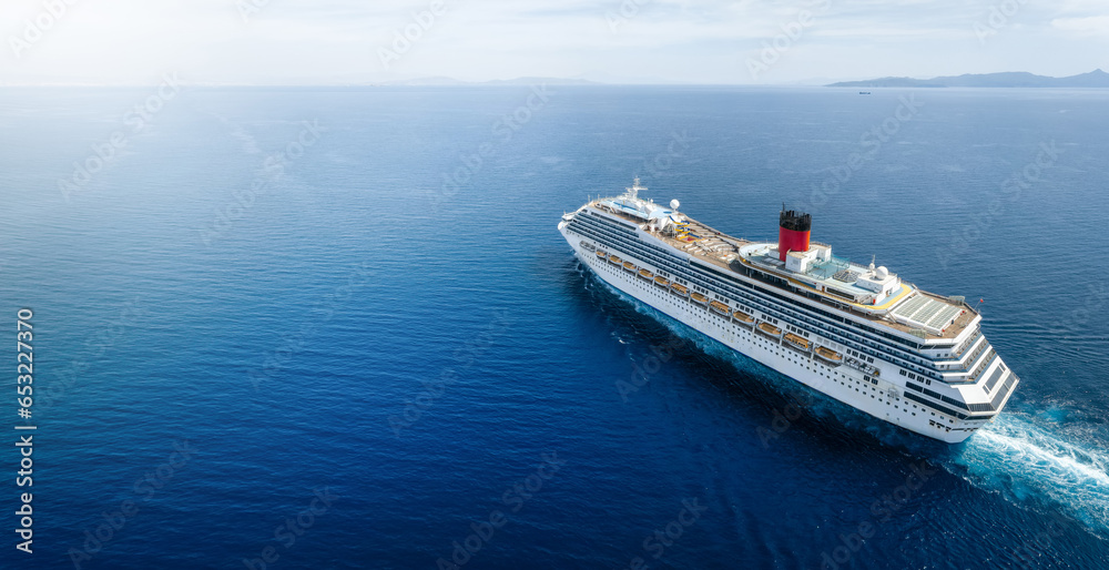 Concept for vacation and travel with a cruise ship sailing over the ocean with copy space - obrazy, fototapety, plakaty 
