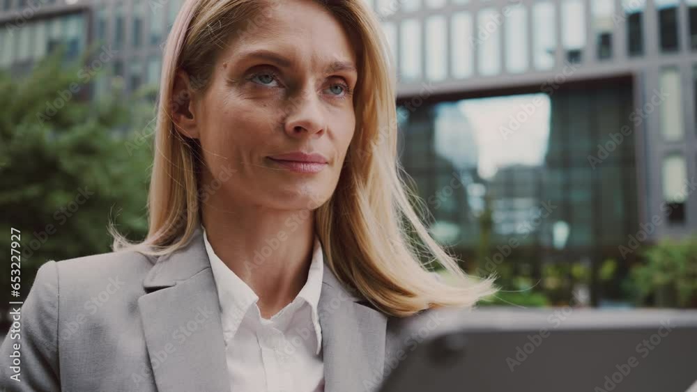 Attractive woman typing on tablet near office building Attractive woman typing on tablet near office building