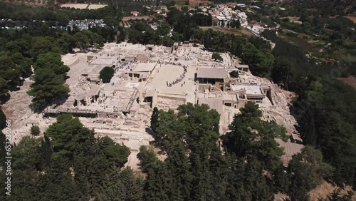 Old Cretan Minoan Palace of Knossos that served as religious and administrative center. Aerial view of stone palace in Greece surrounded by high trees. High quality 4k footage
