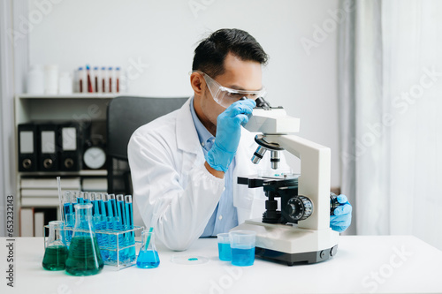 Modern medical research laboratory. male scientist working with micro pipettes analyzing biochemical samples, advanced science chemical laboratory medicine.