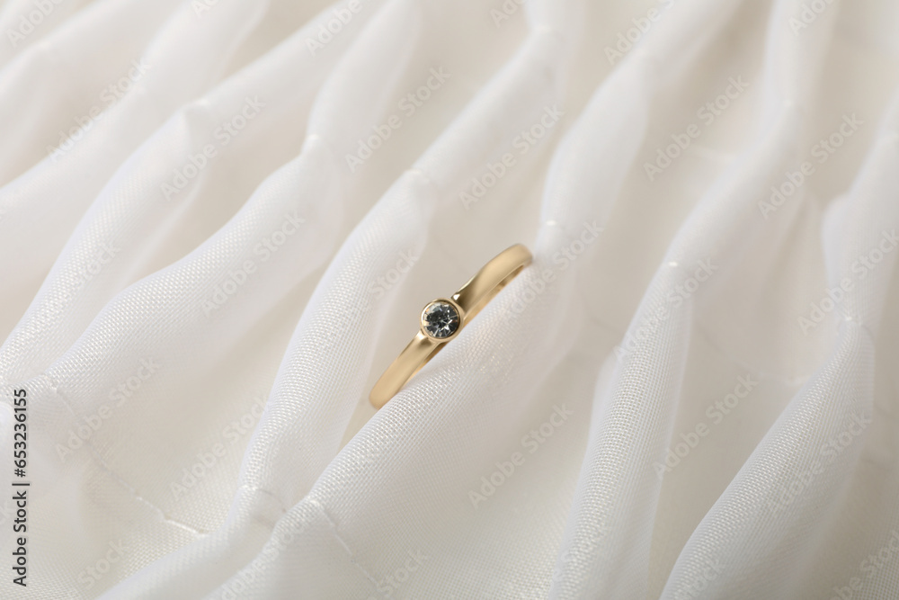 A gold engagement ring in a case, on a light background. A gold engagement ring in a case, on a light background.