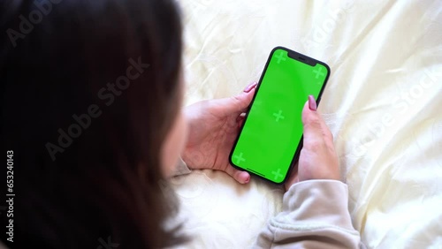 Close up Hand of teenage girl using smartphone with blank chroma key blue screen watching video reel content rear view