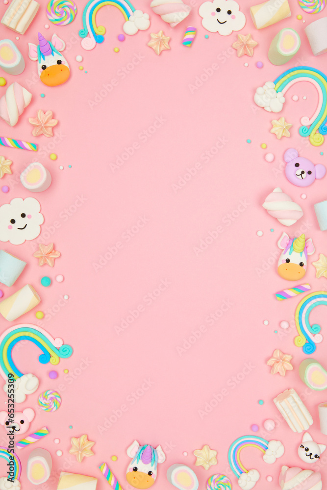 Cute pastel pink kawaii background with frame made of cute air plasticine handmade cartoon animals, unicorns, stars, rainbows. Flat lay, top view, copy space. Beautiful childlike design template