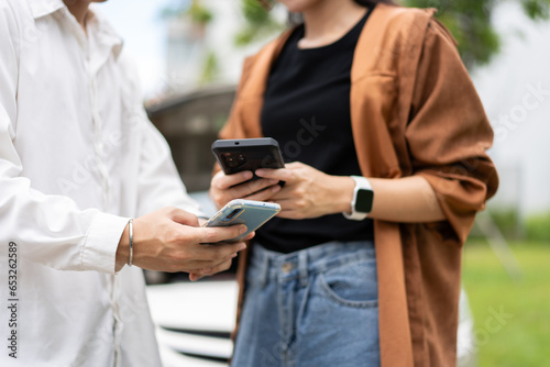 Foto Two Drivers using a smartphone to exchange phone numbers and social media after a car accident