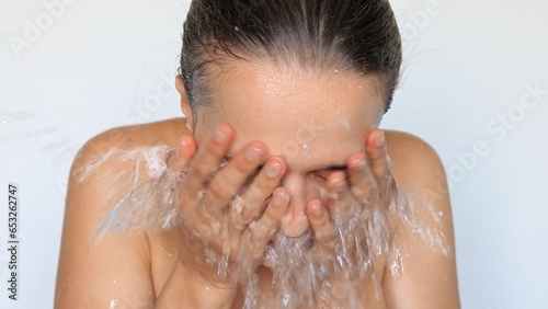 Morning skincare routine. Cleansing for beautiful skin. Spa for skin health. Female facial care. Natural facial moisture. Brunette woman washing het face with water splash isolated on white background photo