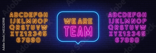We Are Team neon sign in the speech bubble on brick wall background.