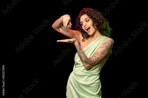 Gambling excited young brunette holding stack of betting chips