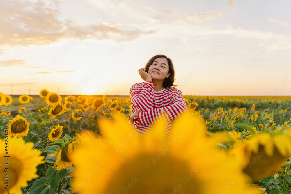 Mature woman amidst sunflowers in field