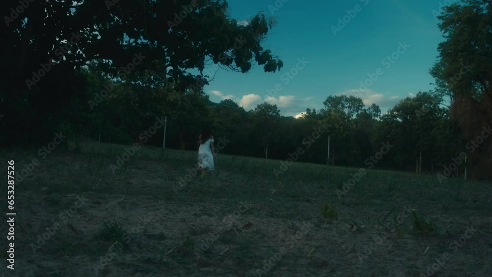 A frightened girl in a bloodstained dress runs away from her pursuer through the woods A frightened girl in a bloodstained dress runs away from her pursuer through the woods