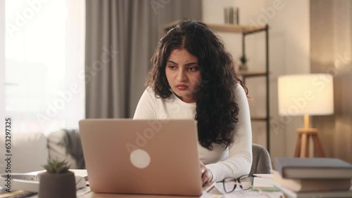 Nervous young woman closed laptop computer with unsuccessful business project at light home Stressed freelancer expressing negative emotion while has professional problem mistake error indoors