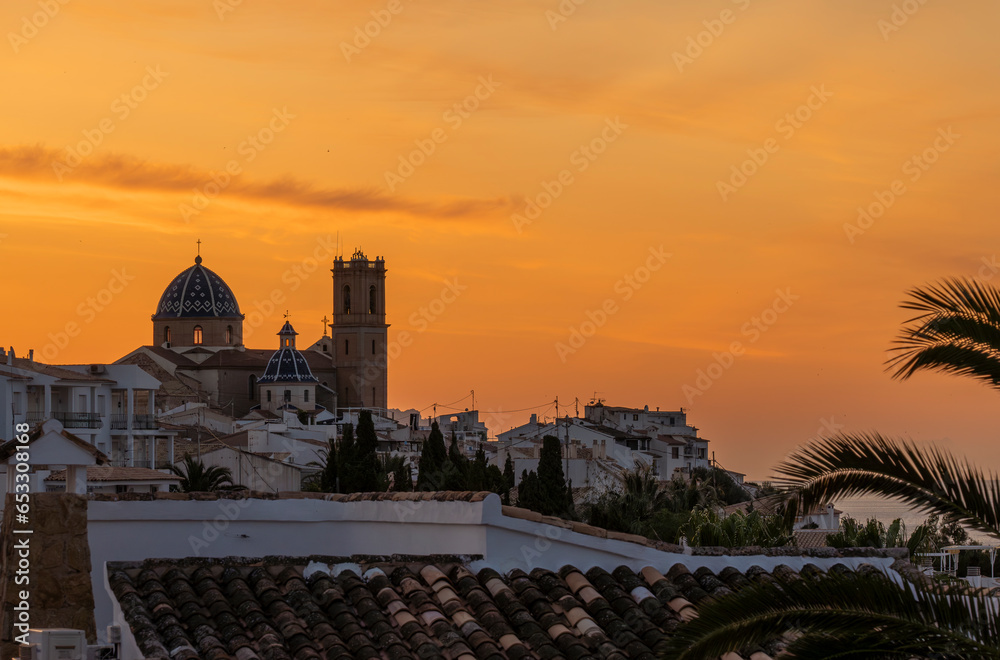 Obraz premium Sunrise with golden sky over the city of Altea with catholic church in the middle colled Nostra Senyora del Consol
