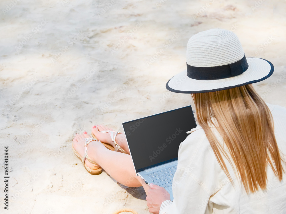 young woman uses laptop computer on the beach. distance work, freelancer and blogger concept. WiFi unlimited