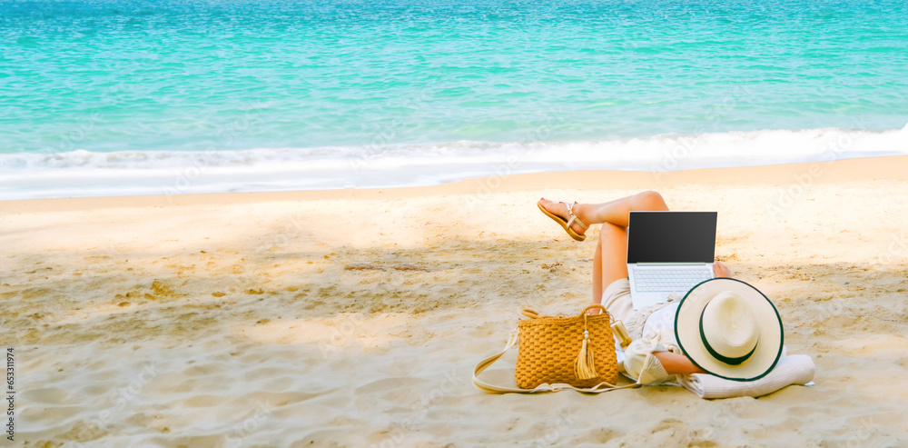 young woman uses laptop computer on the beach. distance work, freelancer and blogger concept. WiFi unlimited