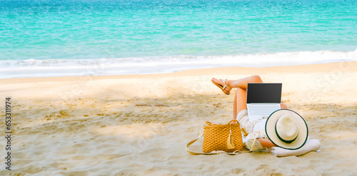 Obraz na płótnie young woman uses laptop computer on the beach. distance work, freelancer and blogger concept. WiFi unlimited w salonie