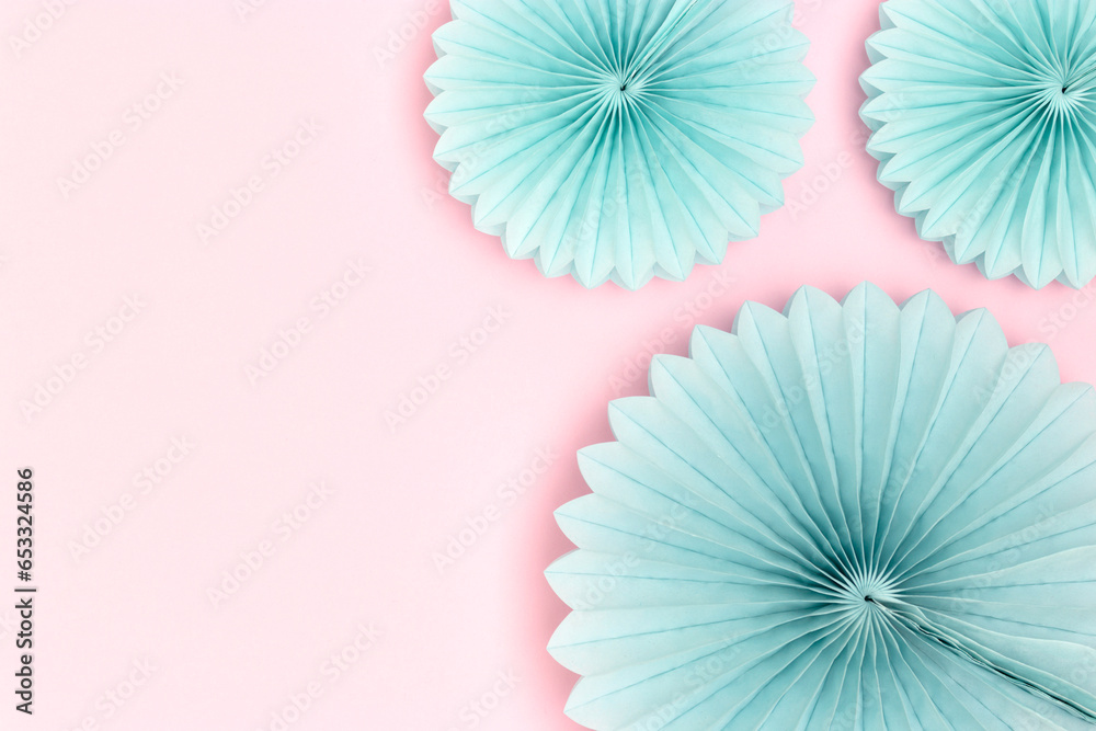 Blue tissue paper fans on a pink background. Place for text.