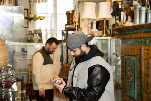 Man checking trinket in antique shop photo