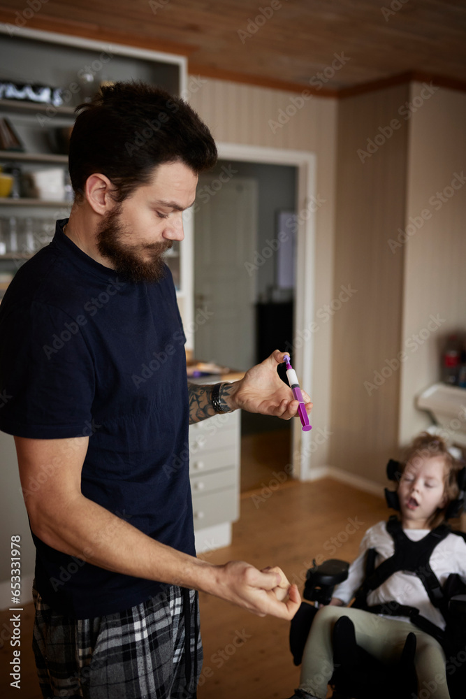 Father preparing nutrition for feeding tube for disabled child Father preparing nutrition for feeding tube for disabled child