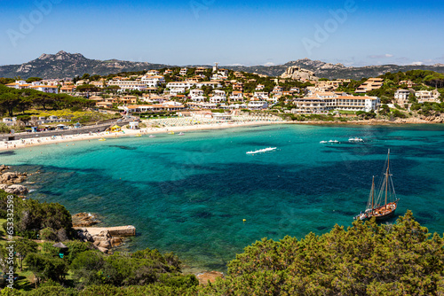 Photos Summer, Cliff Top View Looking Down on the Picturesque Beach of Cala Batistoni and Baia Sardinia Village with Sea Front Shops and Villas