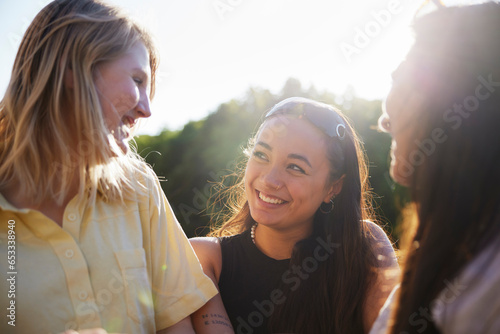 Happy young female friends standing and talking together photo