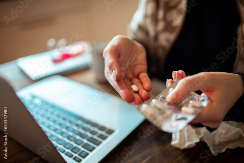 Young Woman taking medication for her illness at home photo