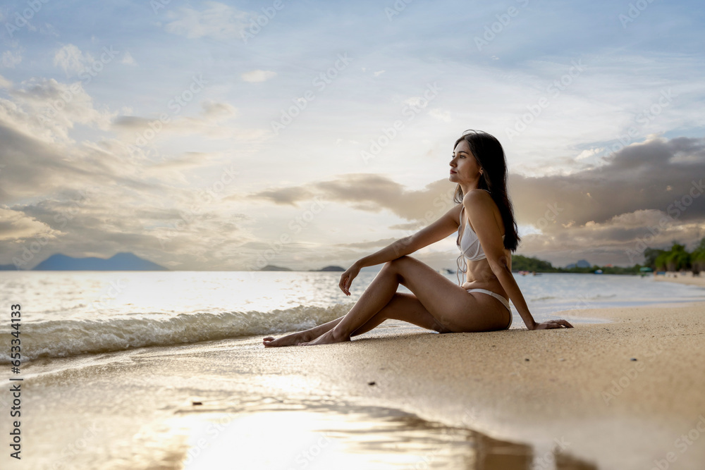 Woman on beach and sand during summer vacation. Beautiful girl on sun tanning in a tropical beach. Female tourist in bikini on sandy beach. Sexy bikini body woman on paradise tropical beach Woman on beach and sand during summer vacation. Beautiful girl on sun tanning in a tropical beach. Female tourist in bikini on sandy beach. Sexy bikini body woman on paradise tropical beach