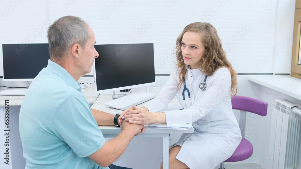 Obraz premium The doctor consults the patient's hands in close-up. The patient is sitting in the doctor's office. Diagnosis, prevention of male diseases, health care, medical care