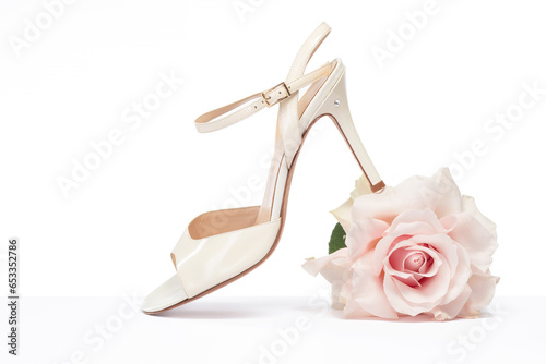 Female tango shoe with a rose on a white background. Argentine tango shoes with a rose. Selective focus