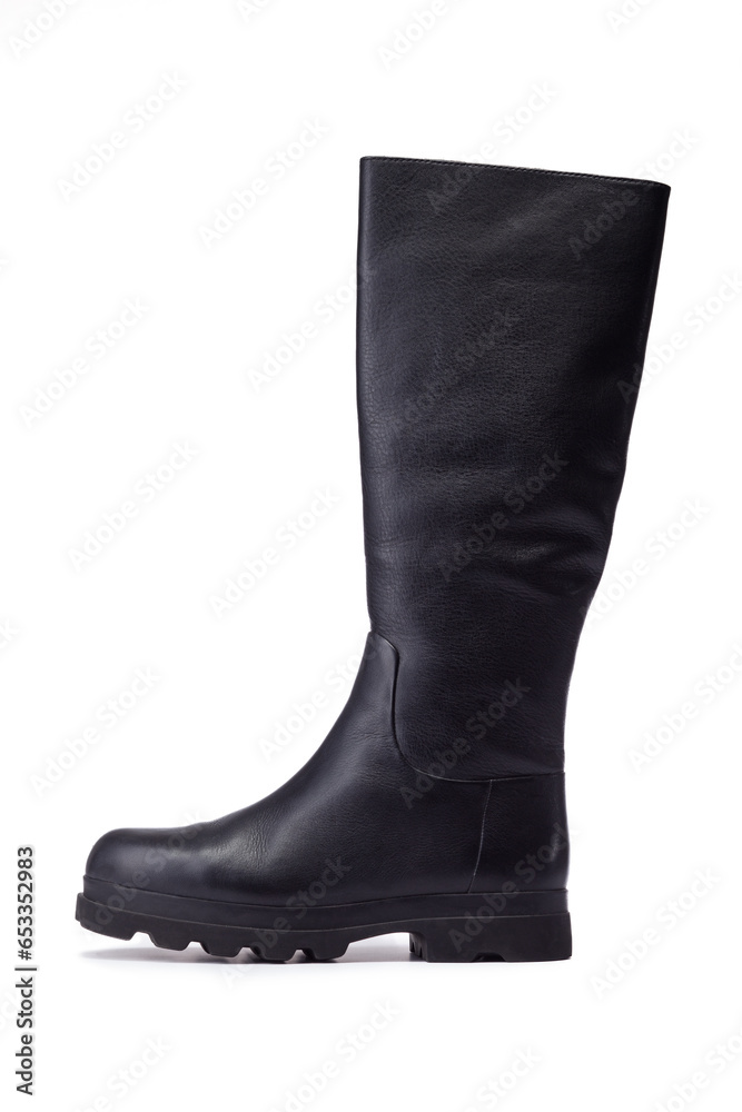 High black boots with thick soles on a white background. Leather female knee length boots on a white background.