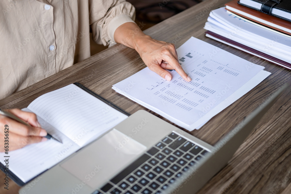Businesswoman working on laptop and papers. Businesswoman working on laptop and papers.