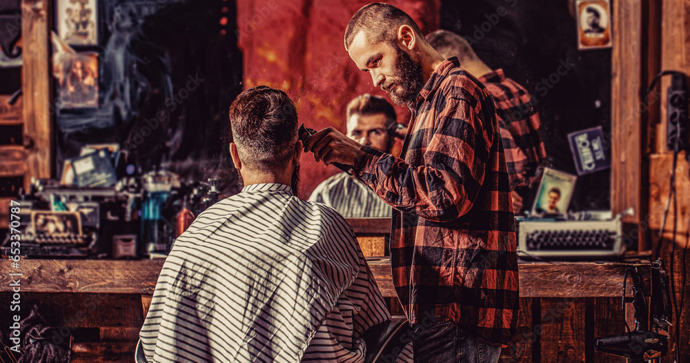 Man visiting hairstylist in barbershop. Barber works with hair clipper. Hipster client getting haircut. Bearded man in barbershop. Haircut concept