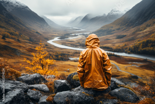 Man admiring beautiful foggy landscape in autumn mountains. Adventurous young man with backpack. Hiking and trekking on a nature trail. Traveling by foot.