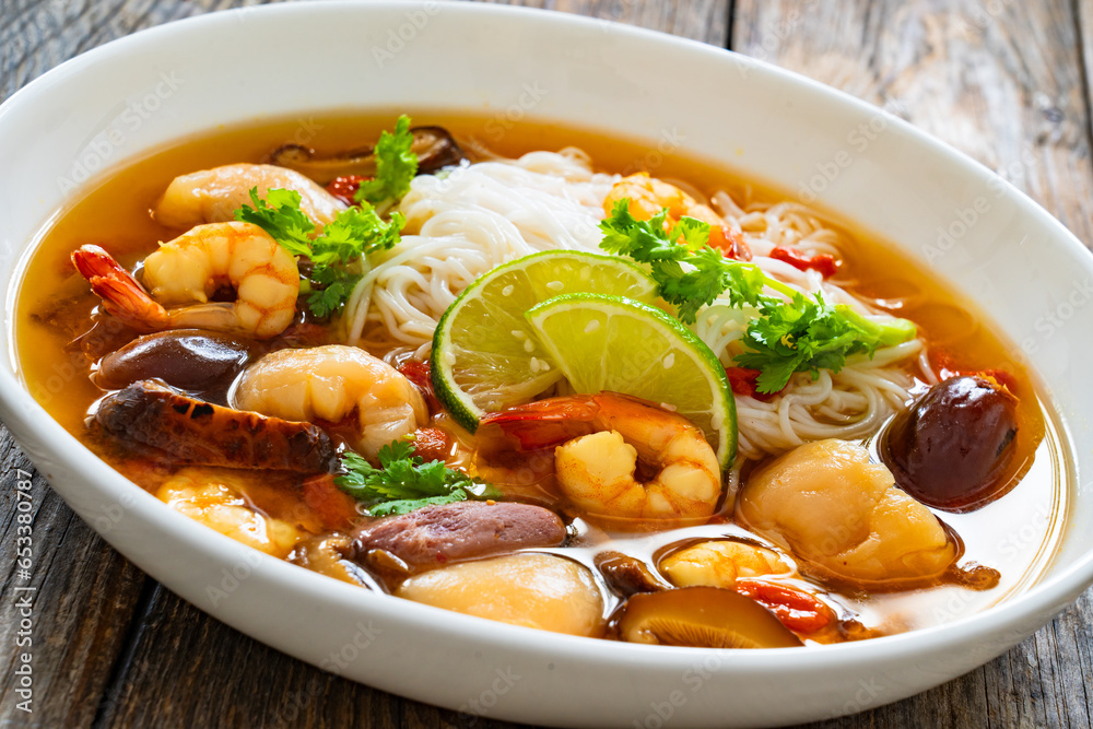 Yunnan hot pot - Chinese soup with shrimps on wooden table
Yunnan hot pot - Chinese soup with shrimps on wooden table