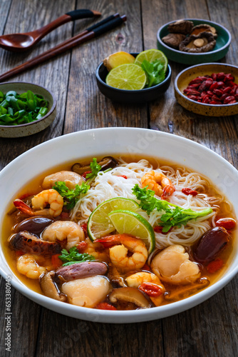 Yunnan hot pot - Chinese soup with shrimps on wooden table
